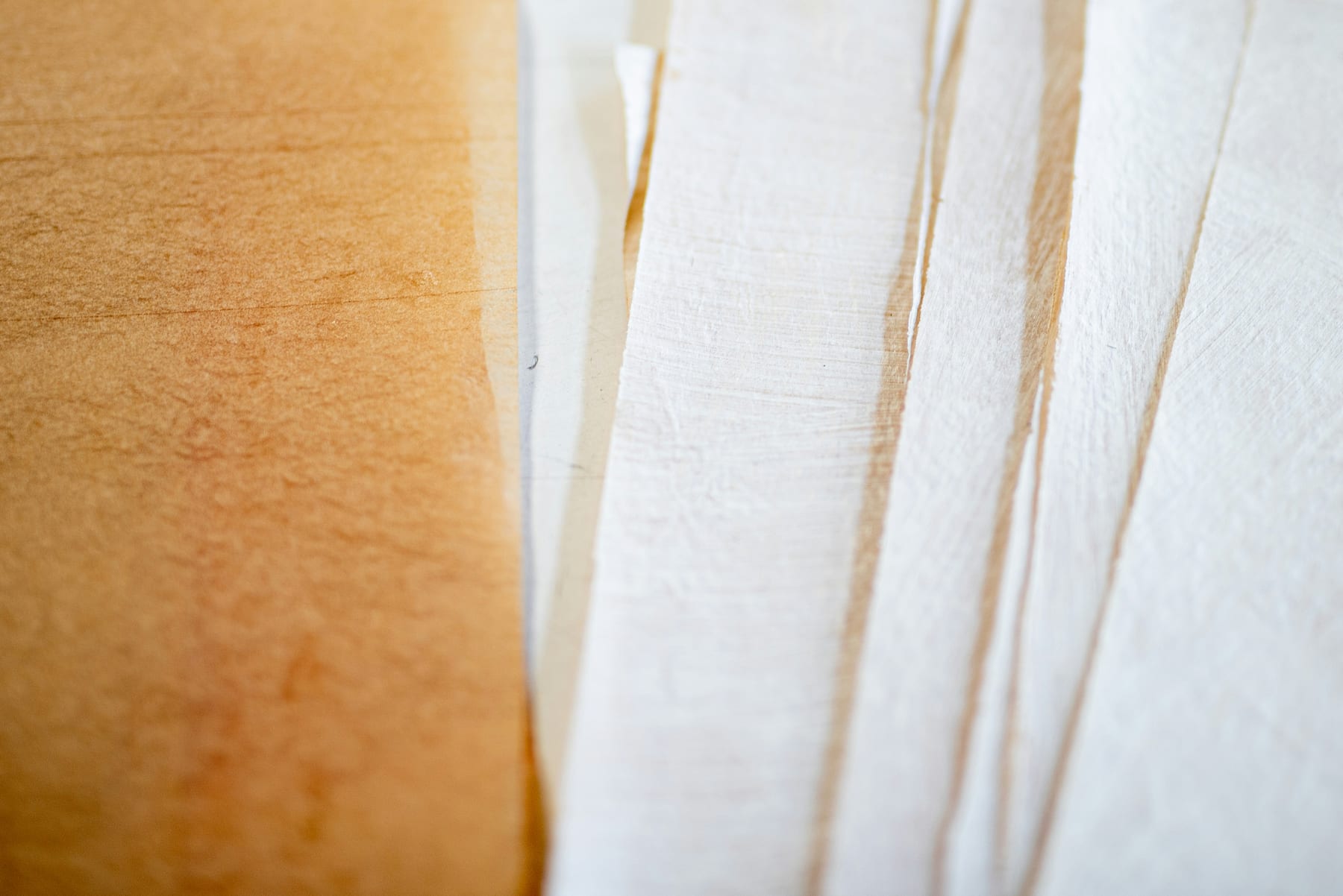 The cut edges of a thick stack of paper, close up in warm light