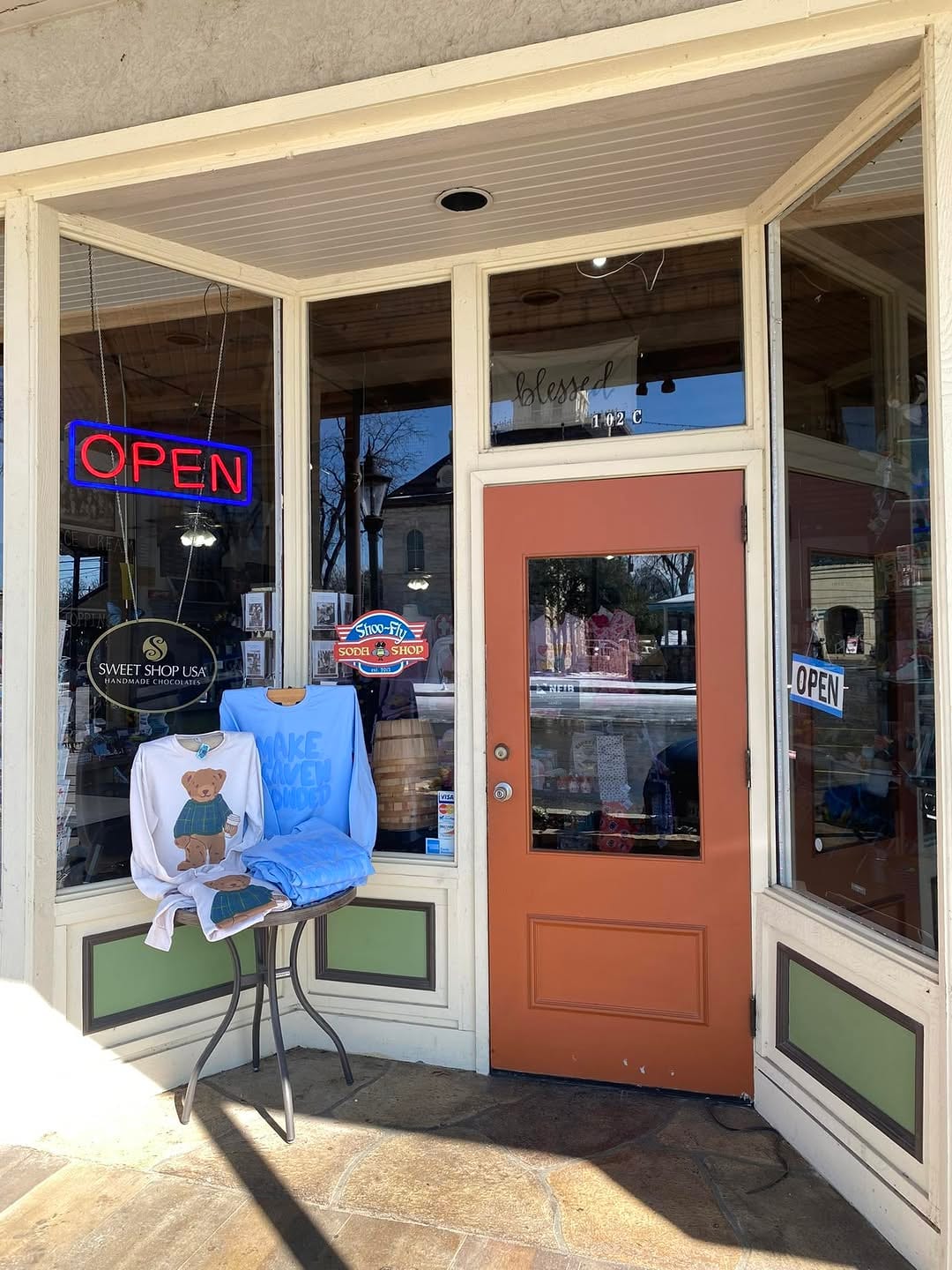 The Shoo Fly Soda Shop storefront, open sign lit.